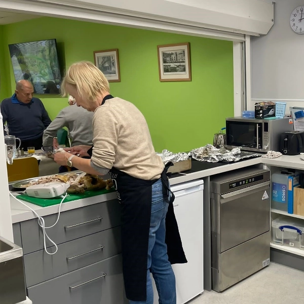 Image of a lady serving food in a kitchen